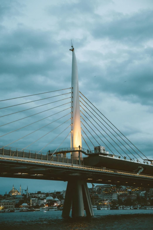 the pedestrian bridge crossing the river has a spire on one end