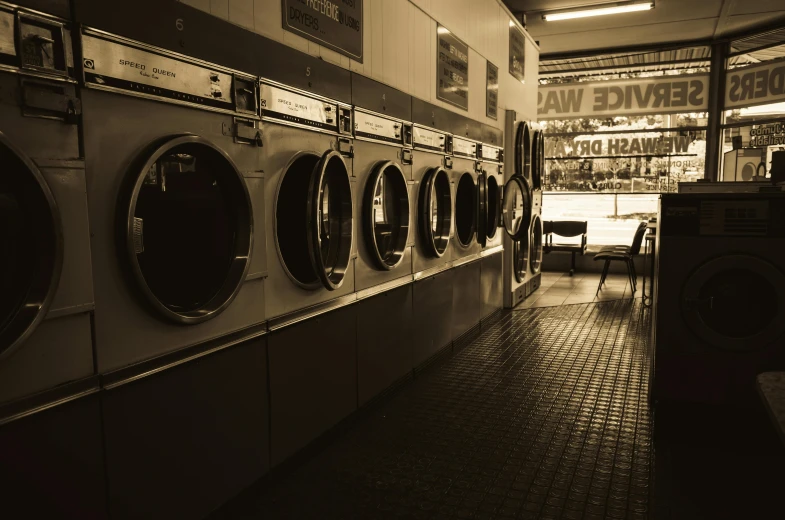 a row of stacked washers in a laundry hall