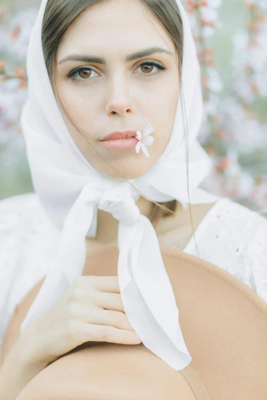 an attractive woman is wearing a scarf around her head