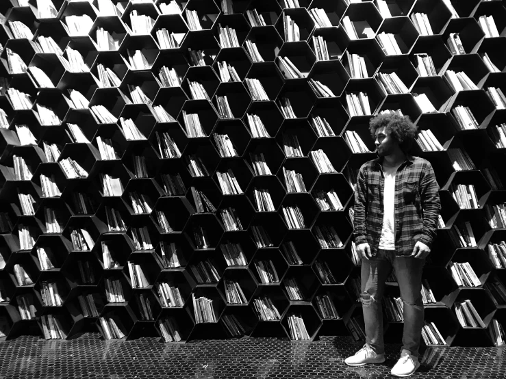 man standing in front of a stack of books on a display