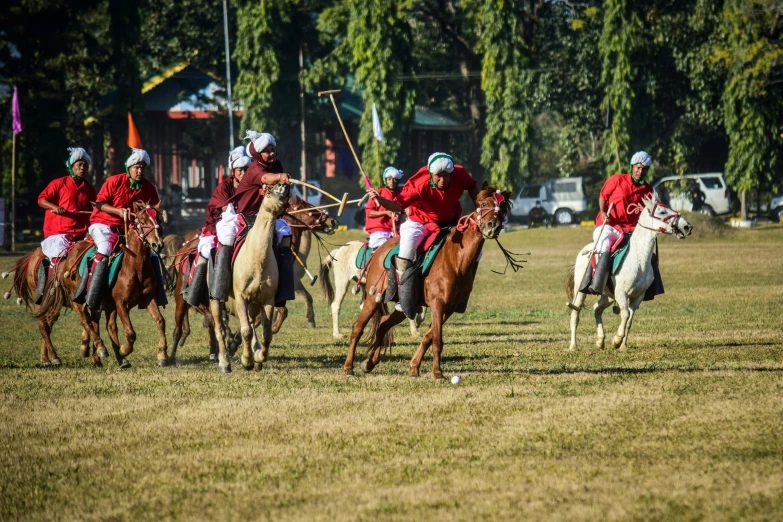 a group of men riding horses across a field