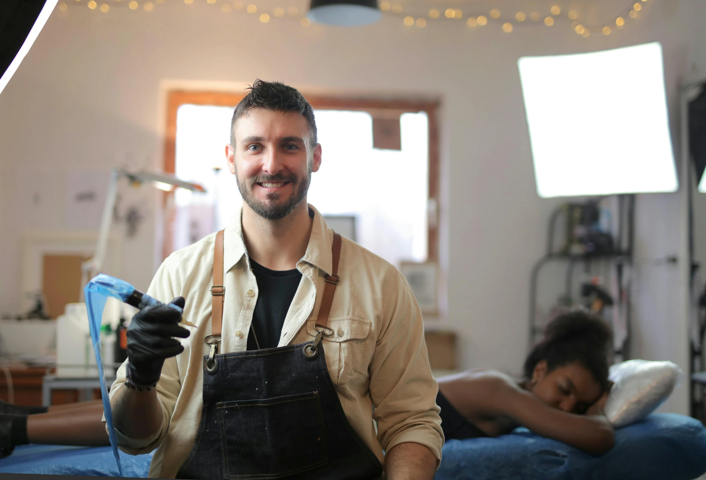 a smiling man in an apartment holding his phone