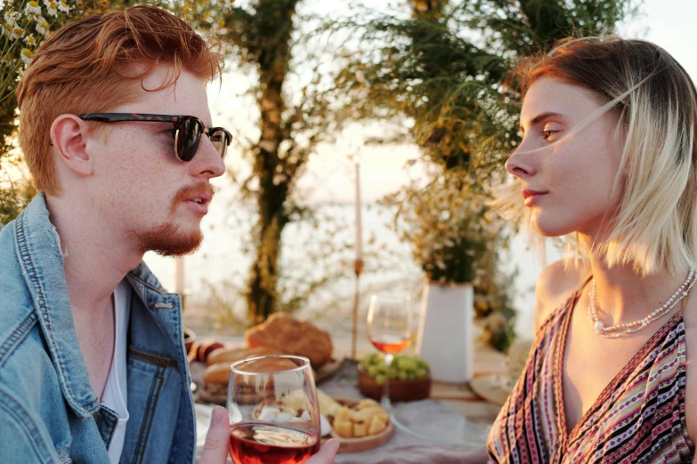 a man and woman drink wine at a dinner table