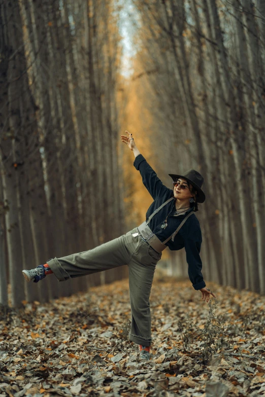 young woman on leaf covered path with outstretched legs