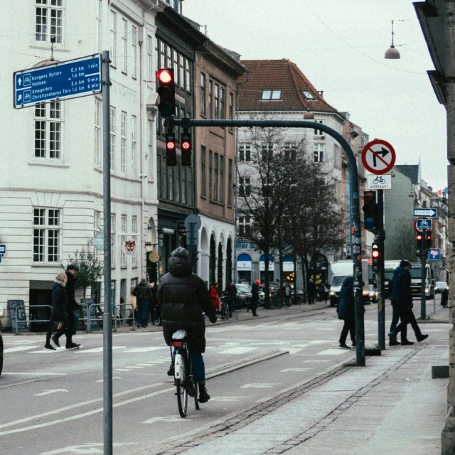 a person riding a bike down a street next to a traffic light