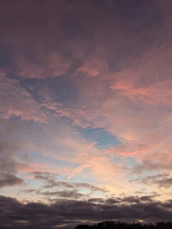 a sunset with clouds that have been colored pink