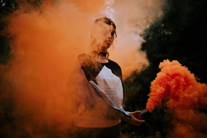 a man standing in front of an orange cloud of smoke