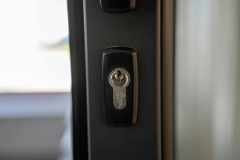 a black door handle with a golden ring