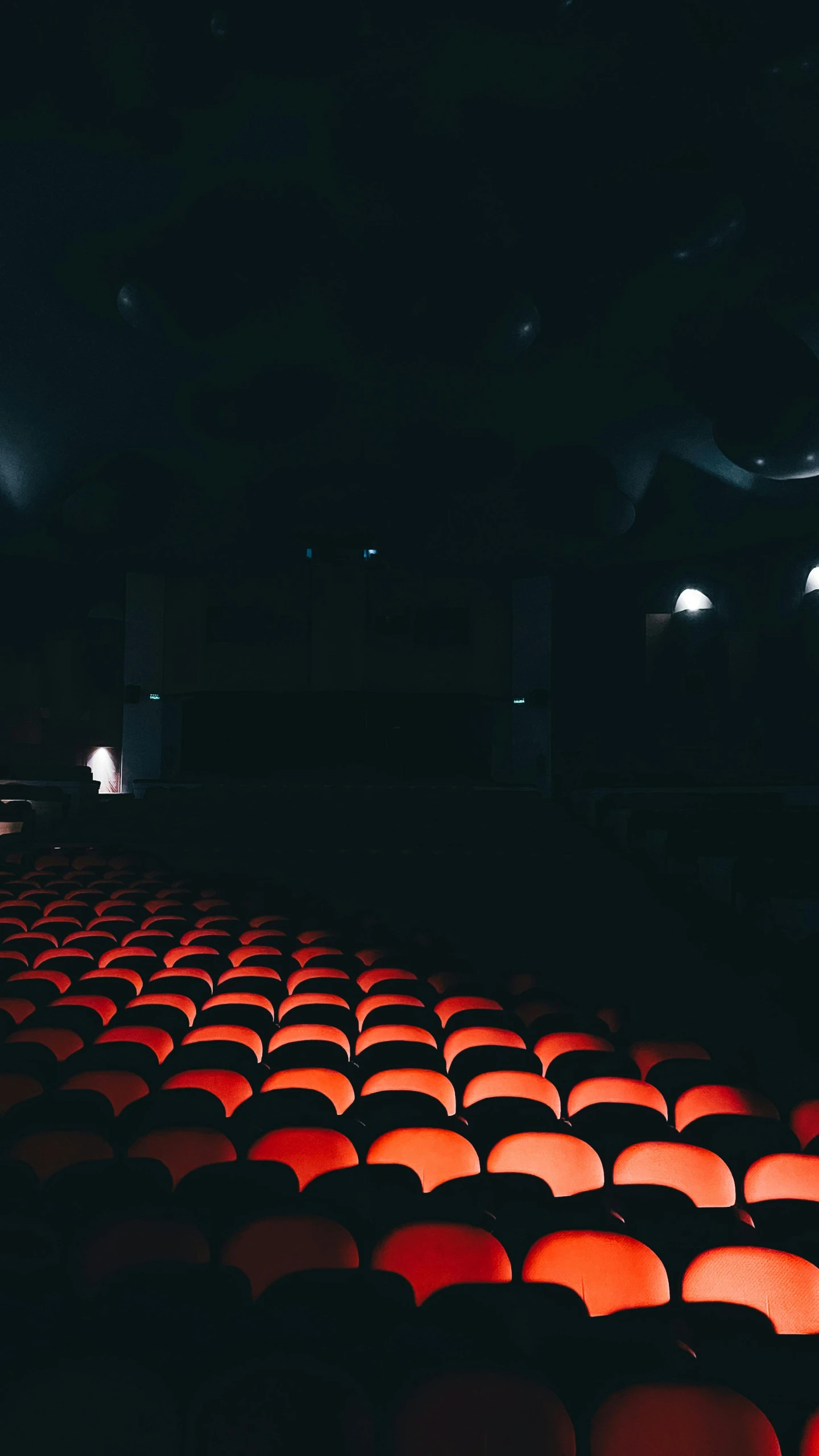 a movie theater with a row of red seats