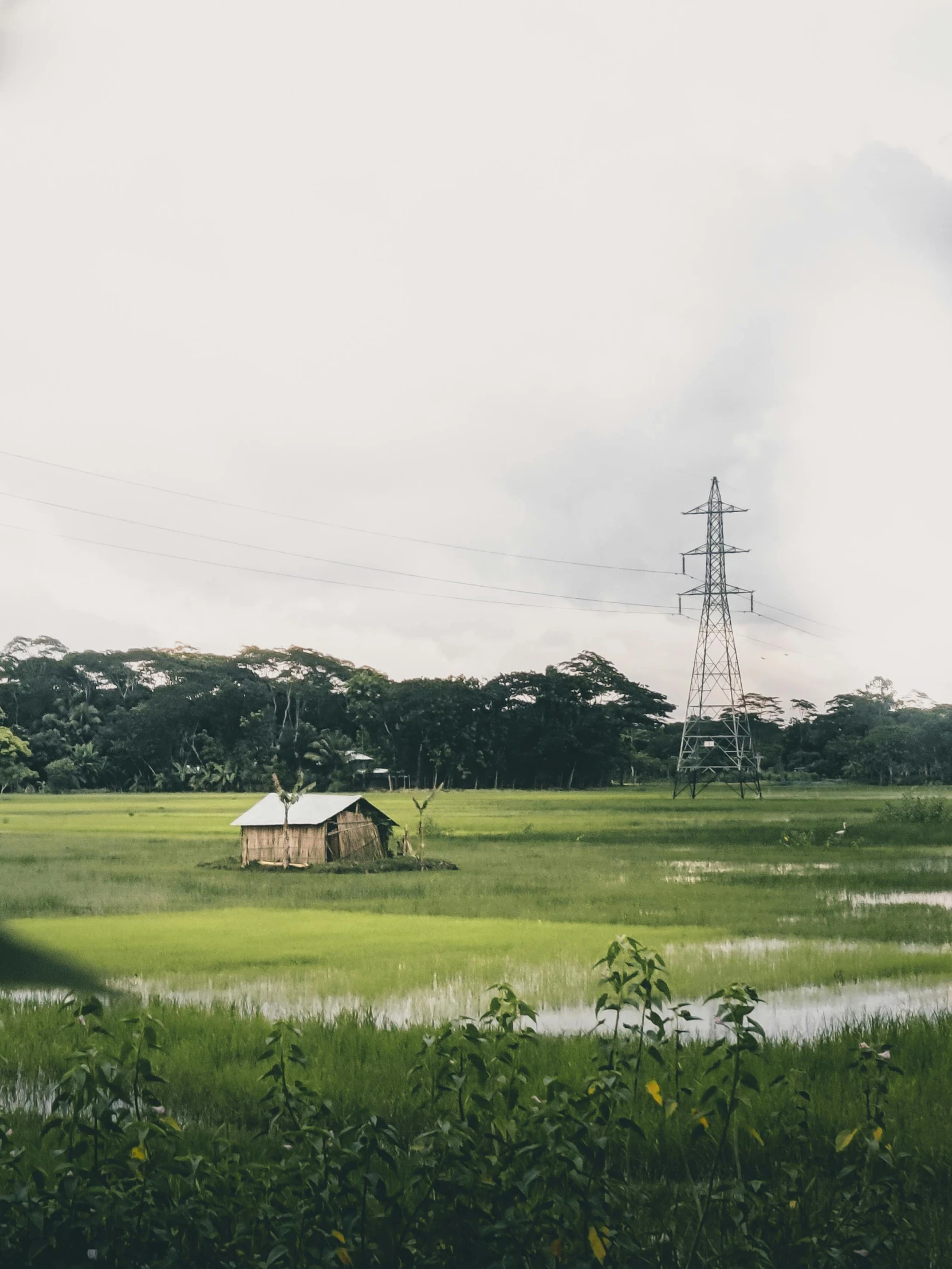 a white building in a field near some water