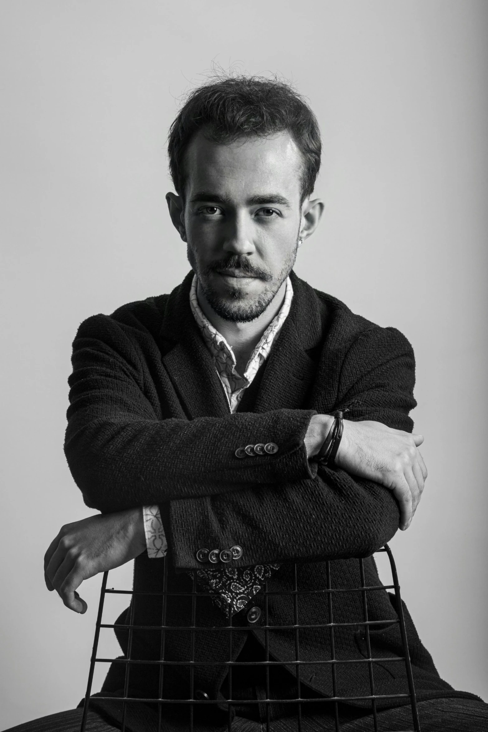 a man with his arm folded on top of a chair