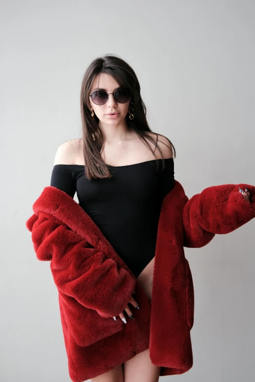 a women in black shirt wearing red fluffy coat