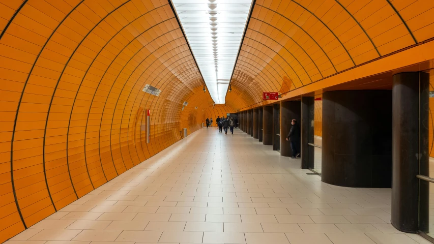 a group of people walking down a large hallway