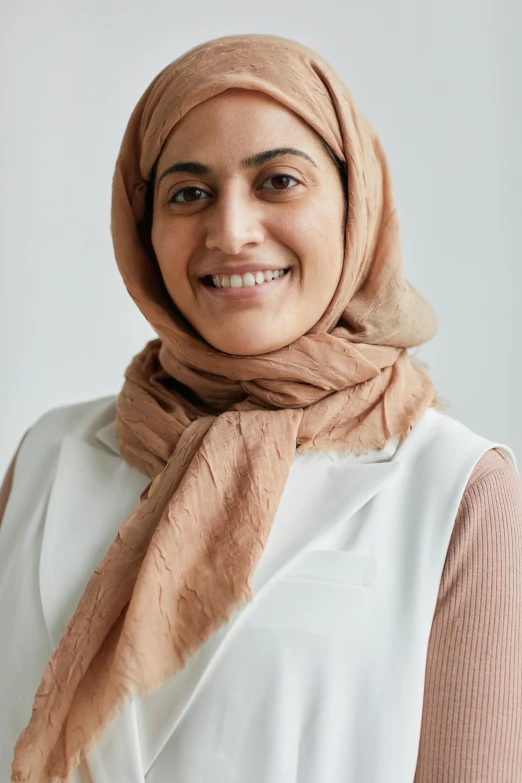 a woman in white shirt wearing a brown scarf