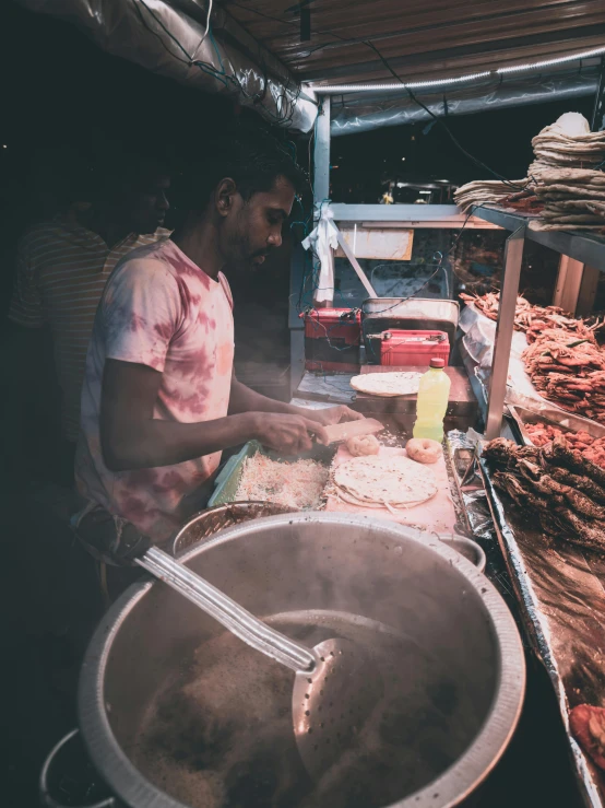 a man preparing food at an outdoor market