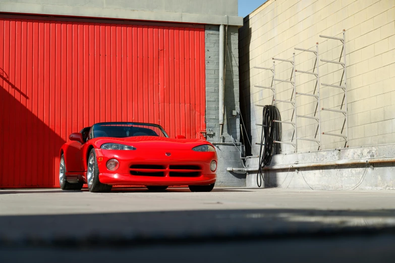 the red sports car is parked in front of a building