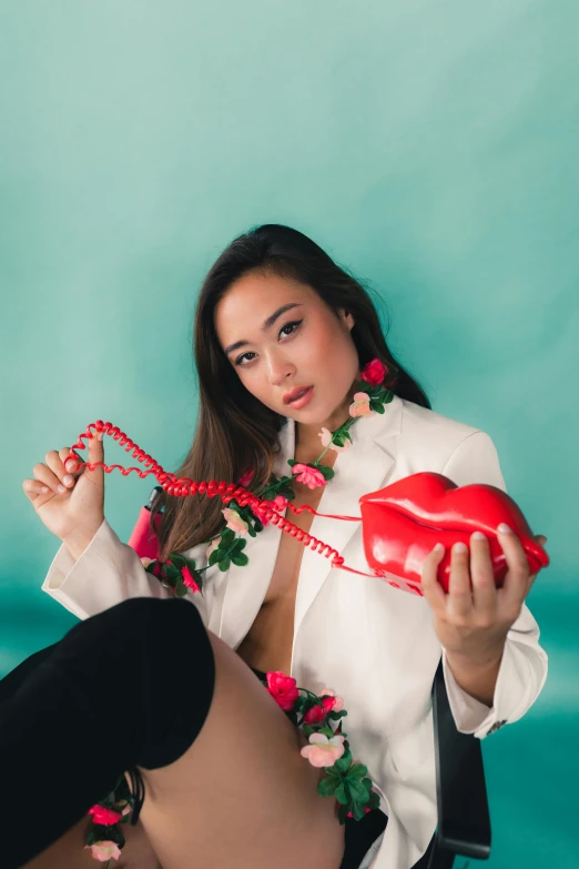 a pretty young lady sitting on top of a chair holding an apple