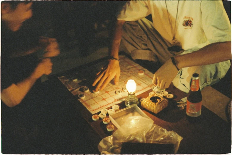 two people sitting at a table together by a candle