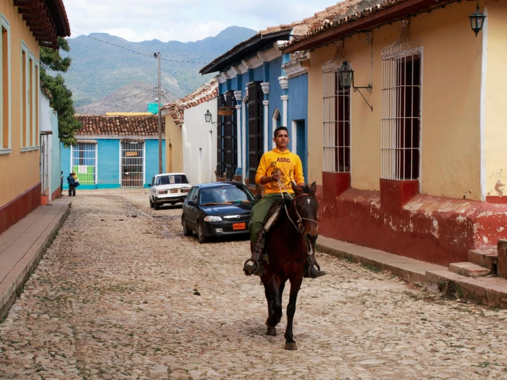 a man is riding his horse through a village