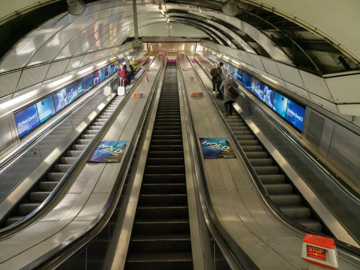 an escalator next to a man riding a bike at an airport