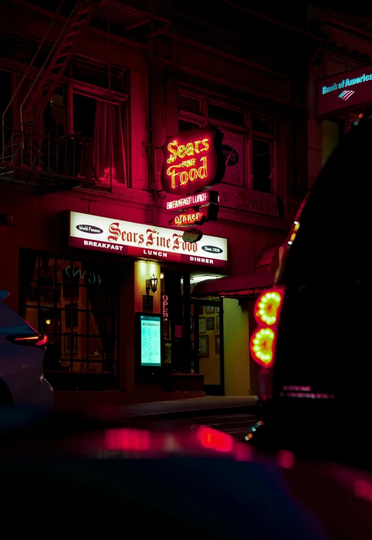 a brightly lit neon restaurant and parking lot