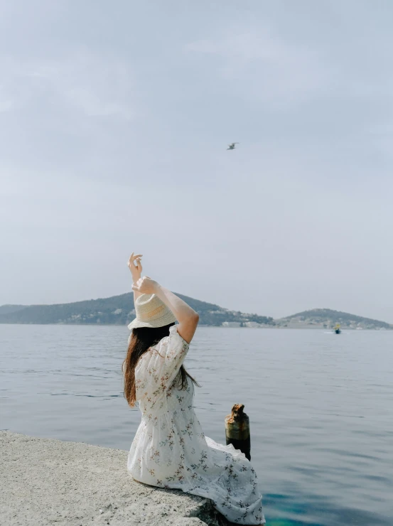 a woman sitting on the edge of a body of water