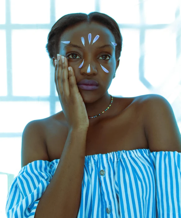 a woman is wearing white makeup, while holding her hand over the eyes