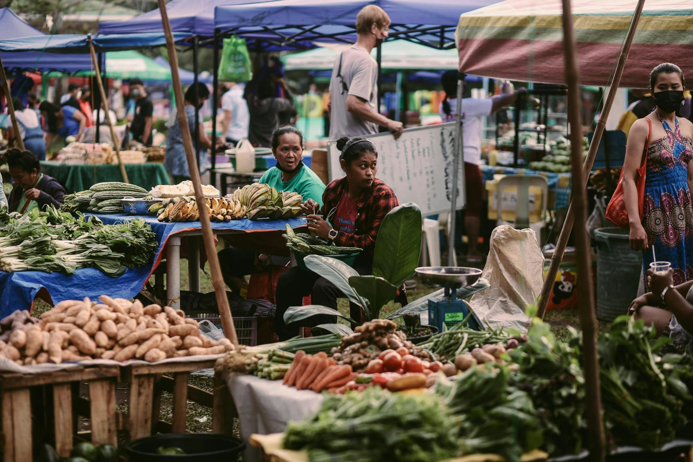 a bunch of people at an outdoor market