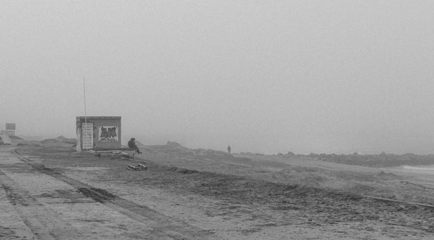 people walking along the beach on a foggy day