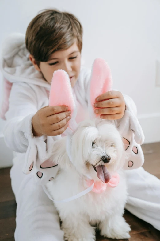 a white dog is sitting on a person wearing bunny costumes