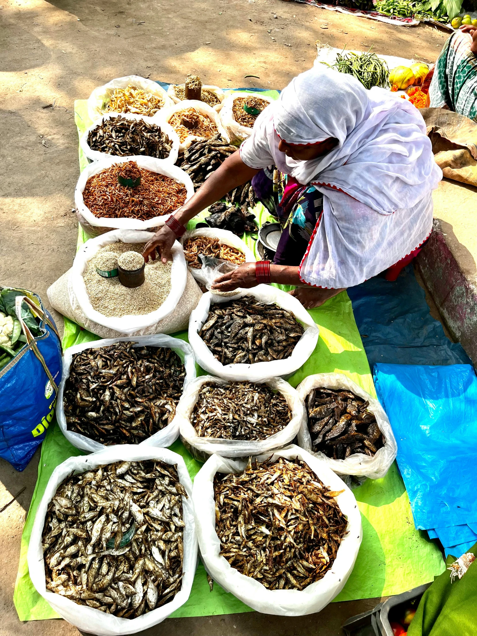 women working at various tables of dried herbs