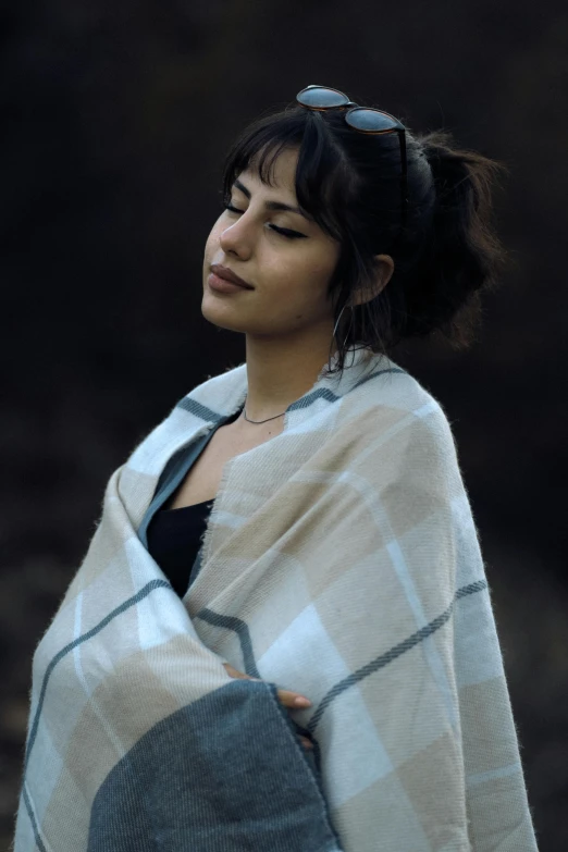 a woman with a large black and white checked scarf wrapped around her neck