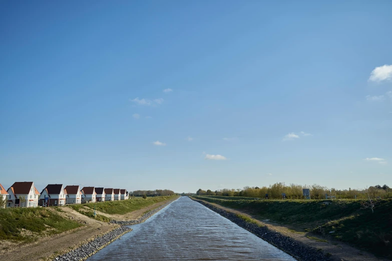 houses sitting on land next to water and grass