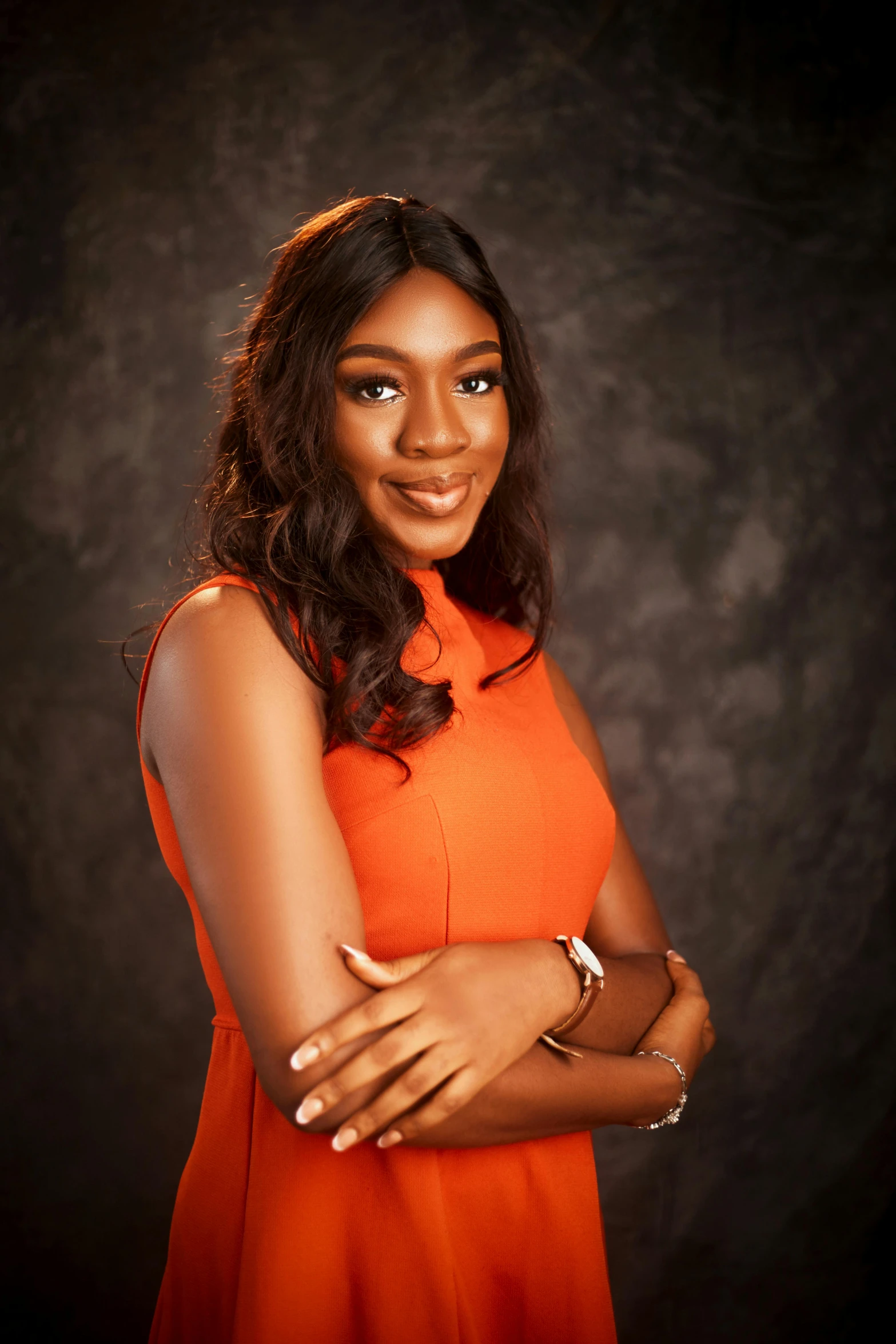 a beautiful woman posing for a studio portrait in an orange dress