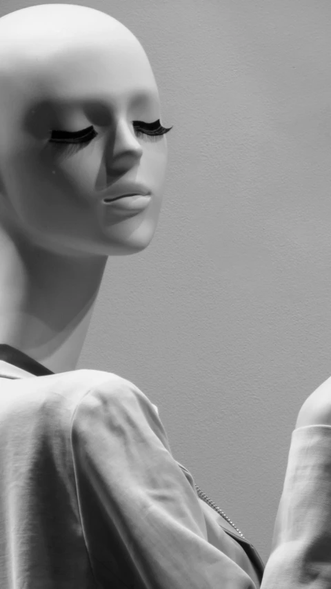 a mannequin head wearing a white t shirt with black lashes