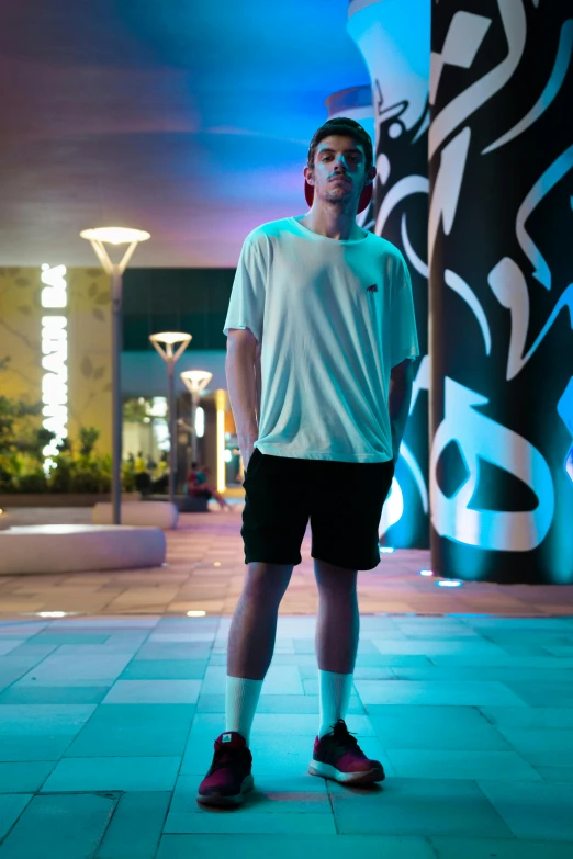 a young man standing in front of a building with a big smile on his face