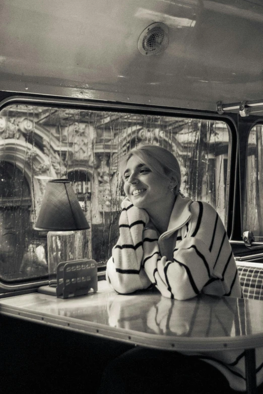 a woman sitting at the table on top of a bus