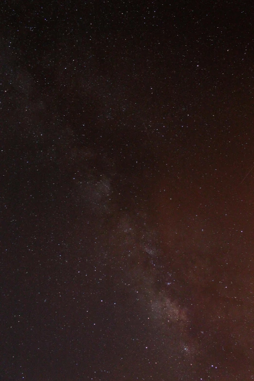 a view of some starry sky with two lights and trees in the foreground