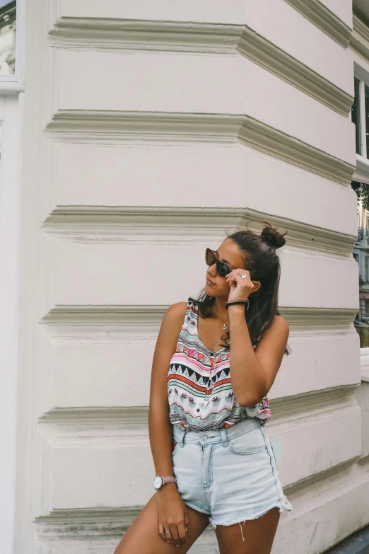 a woman on a cellphone stands by a building