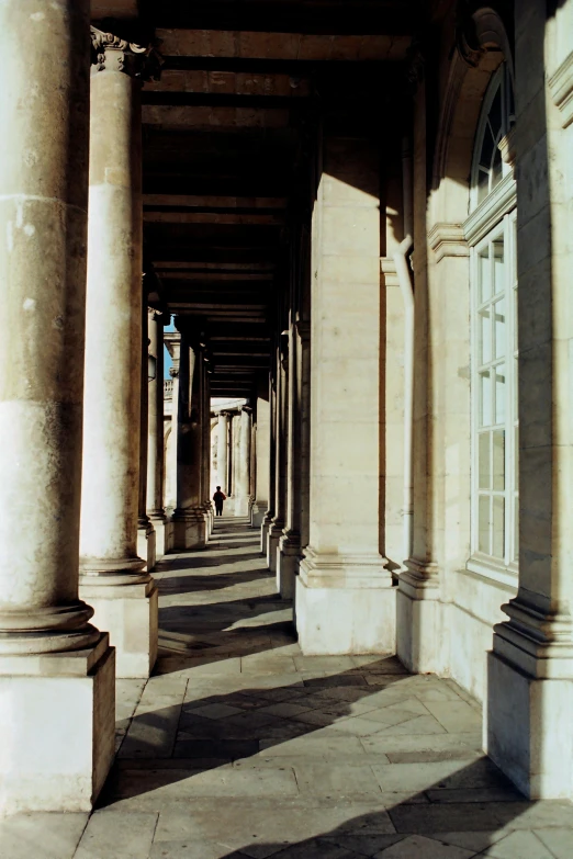 an empty sidewalk near pillars and windows