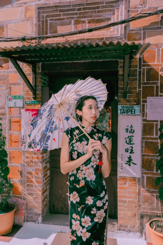 a woman is holding an umbrella near a building