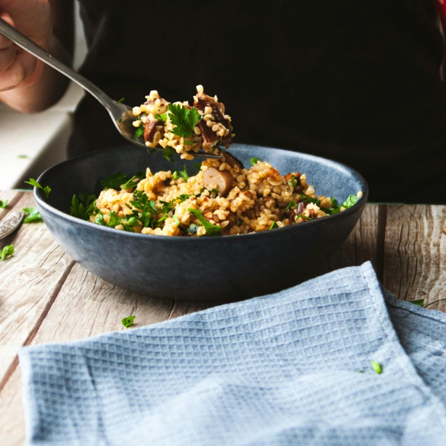 someone is eating food that includes greens in a bowl