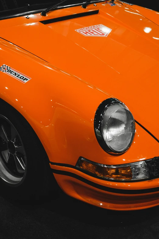 an orange old classic car parked in a garage