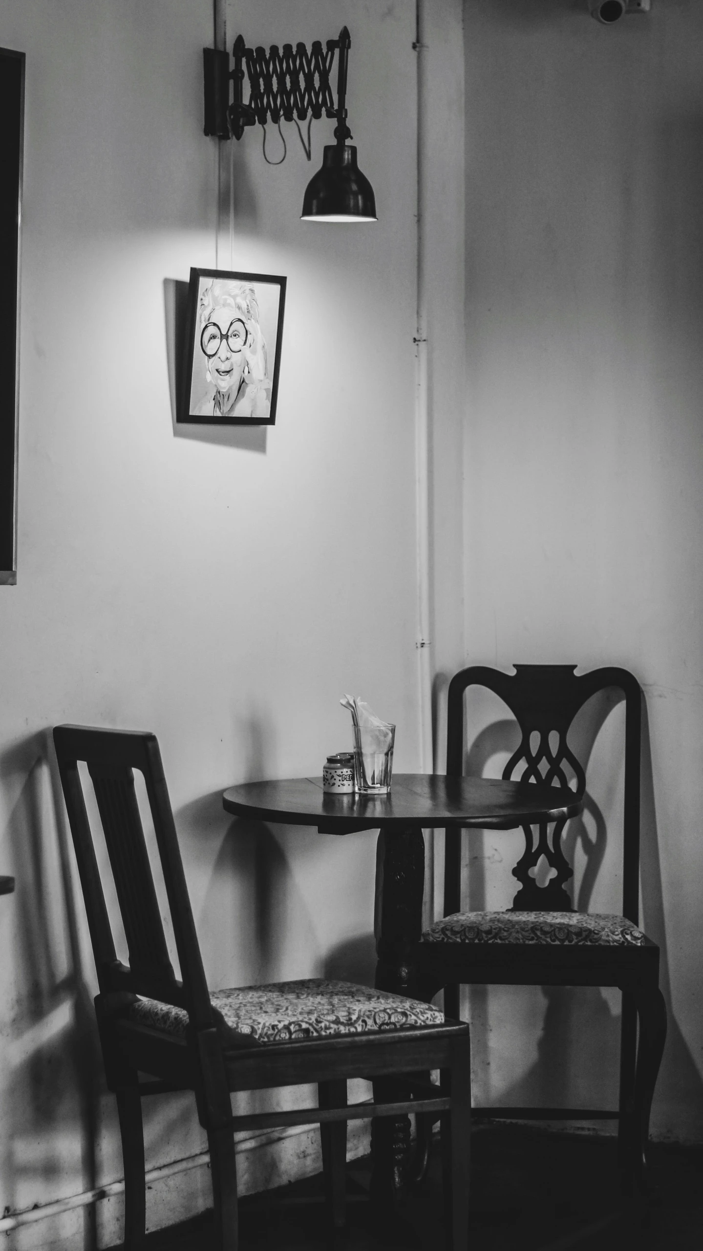 the corner of a dining room with a small table and chairs