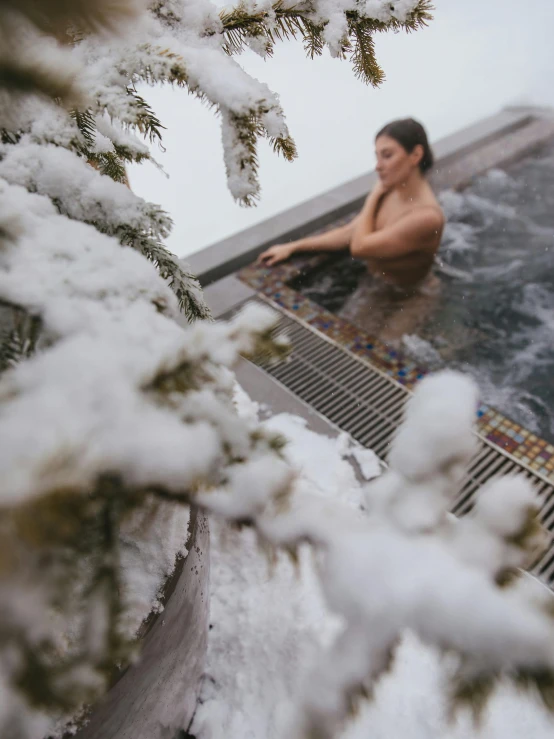 a person in a  tub, with snow