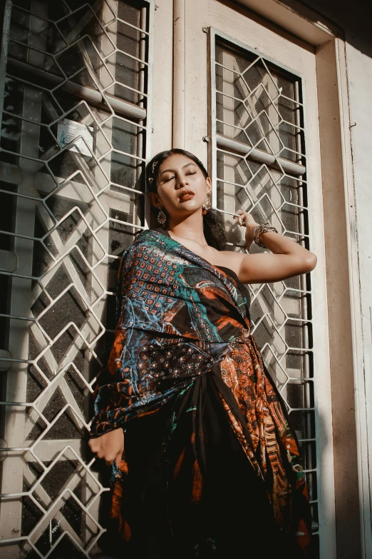 woman in dress sitting against door with hands on hips