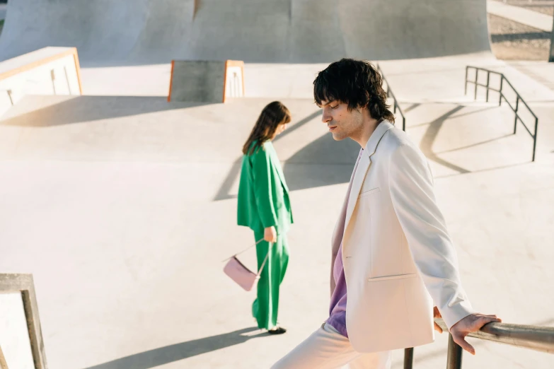 one young man is walking in a skate park with another person