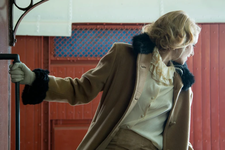 a woman holding a coat in a garage