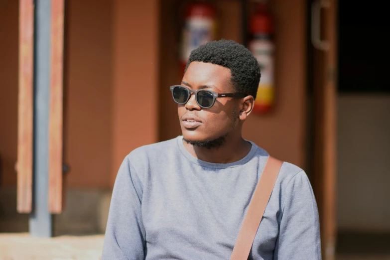 the young man wearing sunglasses and a strap is on the street