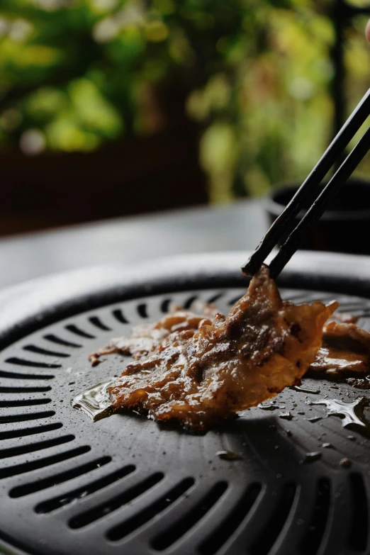 a person is grilling on a charcoal grill